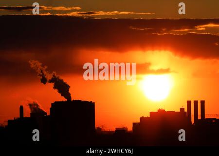 Pennacchi di fumo provenienti dai camini di una centrale combinata di calore ed energia e di una centrale di scarto-energia al tramonto, Berlino, 26/04/2021 Foto Stock