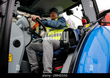 Poznan, Polonia. 9 febbraio 2024. Un agricoltore della grande Polonia siede sul suo trattore mentre blocca la strada Aleja Niepodleglosci durante lo sciopero degli agricoltori a livello nazionale. La protesta in Polonia fa parte della protesta degli agricoltori europei contro i regolamenti del Green Deal dell'UE. Gli agricoltori polacchi chiedono inoltre una modifica dell'accordo UE con l'Ucraina in merito all'importazione di prodotti agricoli nell'UE. La protesta a Pozna?, la capitale della grande Polonia, fu organizzata da Rola Wielkopolska, con oltre un migliaio di trattori visti bloccare le strade della città. Credito: SOPA Images Limited/Alamy Live News Foto Stock