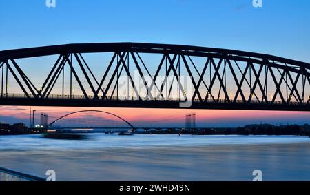 Scatto di lunga esposizione di un ponte la sera con barca e acqua offuscata dal movimento. De Oversteek e Snelbinde, Nimega Paesi Bassi. Foto Stock