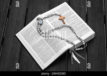 Traduzione standard della Bibbia con rosario in legno di oliva, aperta a Genesi, Paradiso Foto Stock