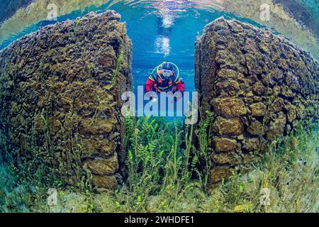 Il subacqueo nuota attraverso una parete sommersa in un lago primaverile in Abruzzo, Italia Foto Stock