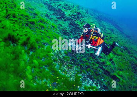 Tuffatori con macchina fotografica che nuotano in un lago primaverile in Abruzzo, Italia Foto Stock