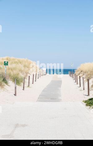 Cielo blu in una giornata estiva sulla spiaggia che attraversa e conduce al mare a Warnemünde, città anseatica di Rostock, costa del Mar Baltico, Meclemburgo-Pomerania occidentale, Germania, Europa Foto Stock