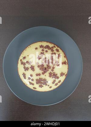 Torta rotonda con stelle sul piatto su fondo di legno Foto Stock