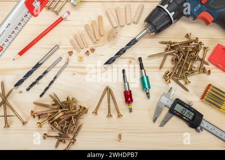 Lavorazione del legno, utensili per la posa di tasselli in legno, vari strumenti di misurazione, fissacavi, trapano per legno, matita, viti per legno Torx, trapano a batteria, fondo in legno, Foto Stock