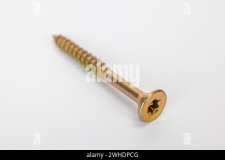 Vite truciolare Torx singola con testa svasata, zincata gialla, sfocata, fondo bianco, Foto Stock
