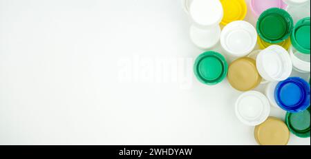 Foto ravvicinata di una pila di tappi per bottiglie in plastica di diversi colori. Concetto di inquinamento della plastica, riciclaggio e sostenibilità. Foto Stock