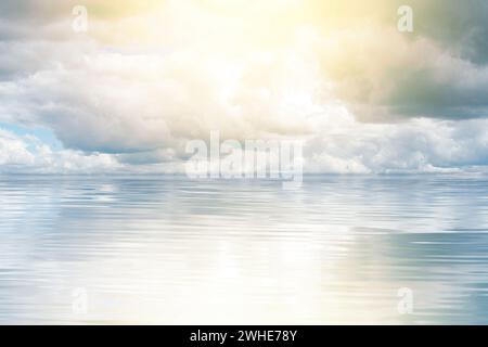 Una fotografia accattivante cattura un momento mozzafiato mentre il sole luminoso penetra attraverso le morbide nuvole, creando un incredibile gioco di luce sul mare. Foto Stock