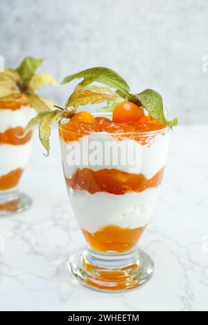 Dessert stratificato con yogurt proteico e frutta fisalis Foto Stock