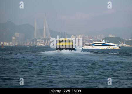 '09.12.2023, Cina, Hong Kong, Hong Kong - traghetti di fronte al ponte Stonecutters sul Mar Cinese meridionale. 00S231209D192CAROEX.JPG [VERSIONE MODELLO: Foto Stock