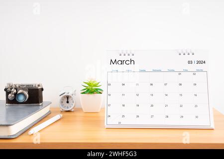 Calendario desktop per l'anno 2024 marzo e fotocamera vintage con diario per Planner per pianificare gli orari presso l'ufficio domestico. Foto Stock
