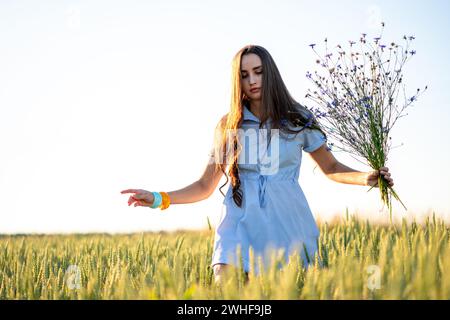 Donna che raccoglie fiori in un campo Foto Stock