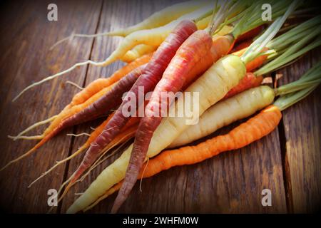 Le carote. Freschi carote colorato scuro su sfondo rustico Foto Stock