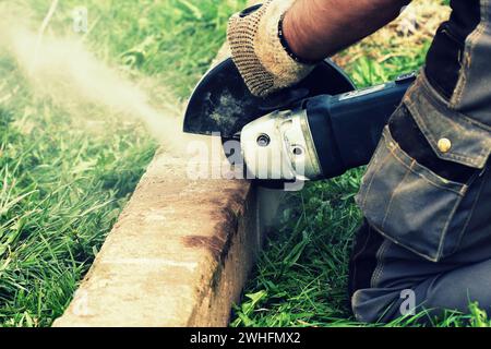 Operaio edile di taglio piastra di calcestruzzo per la fondazione di recinzione utilizzando una troncatrice Foto Stock