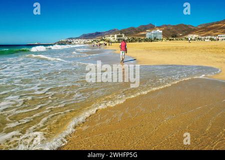 Wunderschöner Spaziergang allein am Strand von Playa del Jandia - gesehen am 17.01.2020. Mitte re. Robinson Club dann RIU Palace sowie hinten der Ort Morro Jable mit li. Der Hafen *** bella passeggiata da sola sulla spiaggia di Playa del Jandia vista il 17 01 2020 centro destra Robinson Club, poi RIU Palace e sul retro il villaggio Morro Jable con sinistra il porto Foto Stock