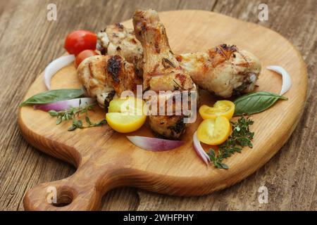 Grigliata di cosce di pollo con rosmarino servita sul tagliere la cena sullo sfondo Foto Stock