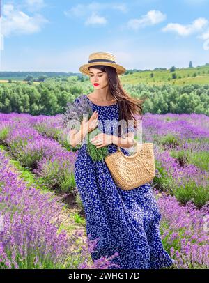 Bella giovane donna in cappello sul campo di lavanda Foto Stock