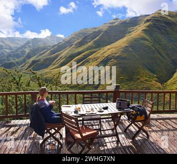 Donna, natura e mangiare su un balcone per vacanze, vacanze e viaggi in un hotel o in un Lodge di campagna. Persona con colazione, cibo e. Foto Stock