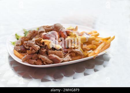 Kebab Doner con patatine fritte e varie salse su un piatto, popolare fast food della cucina turca, spazio copia, focalizzazione selezionata Foto Stock