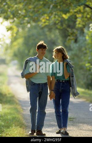 giovani coppie adolescenti che camminano sul sentiero di campagna sfondo verde fogliame Foto Stock