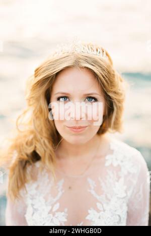 Sposa in un abito in pizzo bianco con una tiara sui capelli Foto Stock