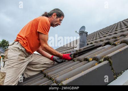 Roofer, operaio sul tetto. Lavori di copertura. tetto piastrellato aperto. Primo passo per la preparazione al solare Foto Stock