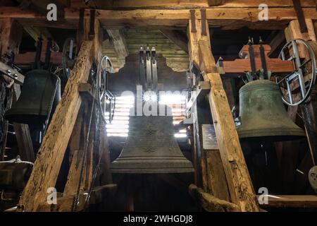 Gudow, Germania, 13 novembre 2020: Tre grandi campane appese a telaio di legno all'interno della vecchia torre della chiesa di Th Foto Stock
