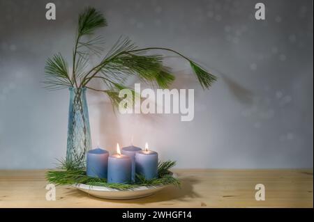 Candele blu, due sono accese per il secondo avvento, e un vaso con rami di pino, decorazione moderna nel periodo natalizio, copia Foto Stock