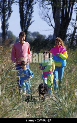 giovane famiglia che cammina in erba verde Foto Stock