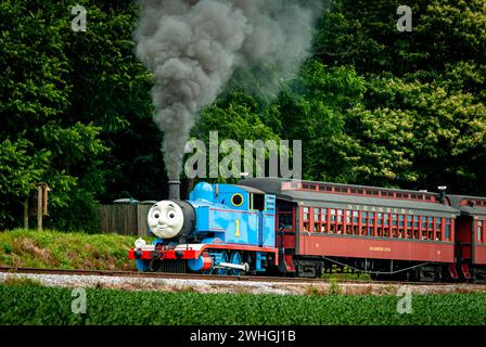 Vista di Thomas the Train Training Passenger Cars Blowing Smoke and Steam Foto Stock