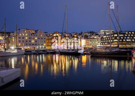 Europa, Norvegia, porto di Tromso di notte con barche ormeggiate in inverno Foto Stock