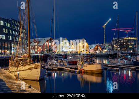 Europa, Norvegia, porto di Tromso di notte con barche ormeggiate in inverno Foto Stock