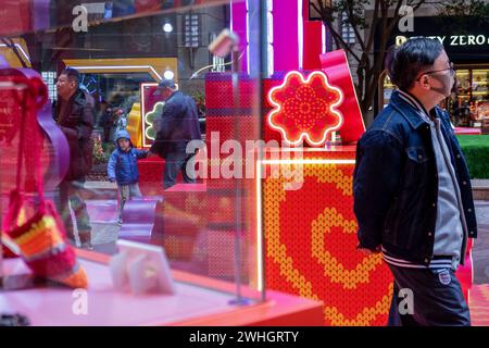 Hong Kong, Cina. 9 febbraio 2024. Le persone camminano intorno a una strada decorata prima del Festival di primavera o del Capodanno lunare cinese. I fiori giocano un ruolo enorme nella celebrazione del Capodanno cinese a Hong Kong e i giorni precedenti la celebrazione del nuovo anno rappresentano il picco annuale delle vendite per il settore. (Foto di Ivan Abreu/SOPA Images/Sipa USA) credito: SIPA USA/Alamy Live News Foto Stock