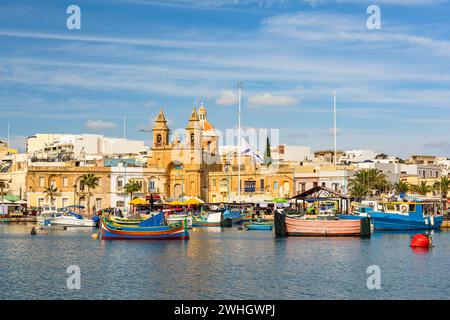 Barche colorate nel villaggio di pescatori di Marsaxlokk a Malta Foto Stock