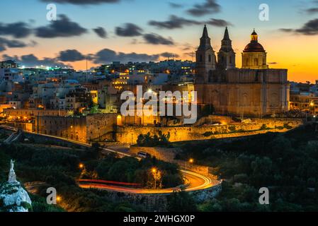 Il-Mellieha, Malta - splendida vista panoramica dello skyline della città di Mellieha dopo il tramonto con la Chiesa di Parigi Foto Stock