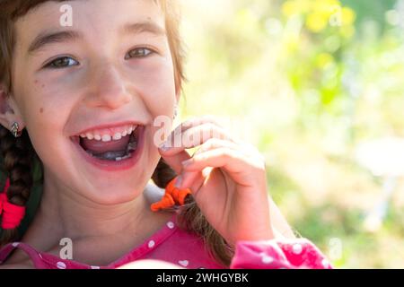 Sorriso felice senza denti di una ragazza con un dente del latte più basso caduto primo piano. Cambiare i denti in molari in infanzia Foto Stock