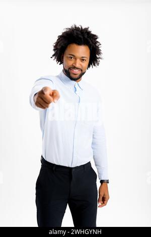 Positivo e sorridente ragazzo afro-americano anni '30 punta il dito alla telecamera, ragazzo multietnico che ti sceglie isolato su sfondo bianco, concetto di offerta pubblicitaria, miglior affare Foto Stock