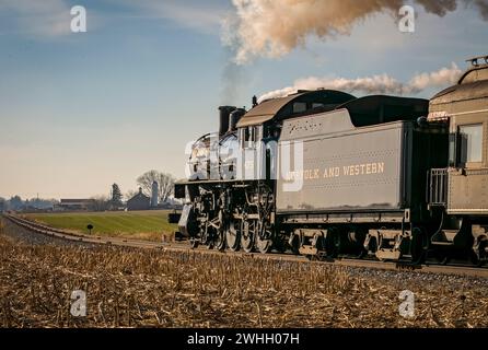 Vista ravvicinata posteriore di una locomotiva a vapore classica che attraversa la campagna Foto Stock