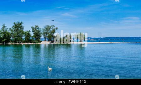 Spiaggia sabbiosa sulla riva del lago Mehrerau vicino a Bregenz con vista su Lindau e zeppelin Foto Stock