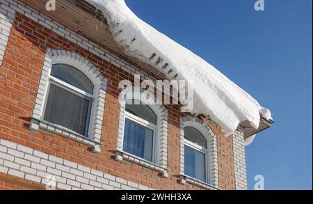 Pericolo di caduta della neve dal tetto. La foto è stata scattata nel bel mezzo dell'inverno. Maggiore pericolo Foto Stock