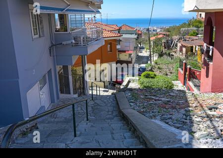 Stretto sentiero pedonale ad Ani poli, la storica città vecchia superiore di Salonicco, in Grecia, con scale lastricate in pietra che scendono fino al centro della città Foto Stock