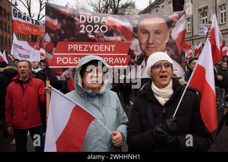 Protesta contro il governo a Varsavia. I manifestanti tengono uno striscione raffigurante il presidente della Polonia Andrzej Duda e sventolano le bandiere nazionali della Polonia durante una protesta anti-governativa a Varsavia, in Polonia, il 10 febbraio 2024. Diverse centinaia di sostenitori del partito PiS Law and Justice si sono riuniti al di fuori del Tribunale costituzionale di Varsavia in una protesta anti-governativa contro la coalizione di governo guidata dal filo-europeo Donald Tusk. Varsavia Polonia Copyright: XAleksanderxKalkax Foto Stock