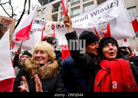 Varsavia, Polonia, 10 febbraio 2024. Persone, che detengono bandiere nazionali polacche e bandiere antigovernative, guidate dai media di estrema destra - Gazeta Polska e TV Republica e diritto e giustizia (Prawo i Sprawiedliwość - PIS) i leader dei partiti politici organizzano una protesta a sostegno degli attuali giudici della Corte costituzionale di fronte all'edificio della Corte in via Szucha. La Polonia attraversa una crisi costituzionale, poiché l'attuale governo centrista afferma che i giudici della Corte costituzionale sono stati insediati illegalmente da un ex governo di destra. L'opposizione di destra dimostra il sostegno dei giudici della Corte. Foto Stock