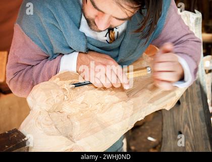 Lavoratore del legno con sgorbia a mano che lavora il pino Foto Stock