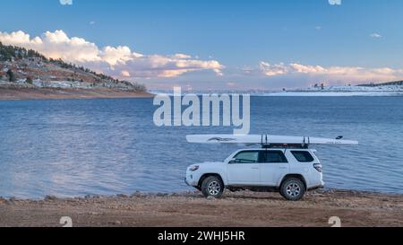 Loveland, CO, Stati Uniti d'America - 8 febbraio 2024: Toyota 4Runner SUV con capanna a remi Liteboat su portapacchi su una riva del lago Carter nel nord del Colorado a wi Foto Stock