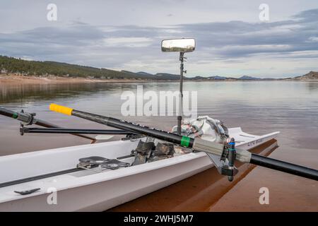 Loveland, CO, USA - 6 febbraio 2024: Conchiglia a remi costiera, Literace 1x di Liteboat, con specchio e borsa impermeabile sulla riva del lago Carter a Nor Foto Stock