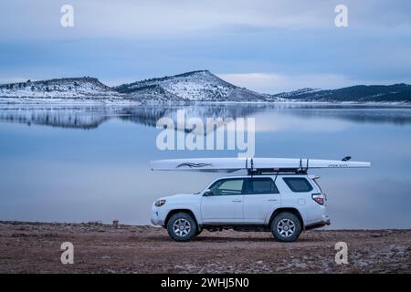 Loveland, CO, Stati Uniti d'America - 6 febbraio 2024: Toyota 4Runner SUV con capanna a remi Liteboat su portapacchi su una riva del lago Carter nel nord del Colorado a wi Foto Stock