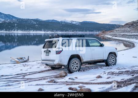 Loveland, CO, USA - 5 febbraio 2024: Toyota 4Runner SUV e una canoa da spedizione su una riva del lago Carter nel nord del Colorado al crepuscolo dopo aver remare Foto Stock