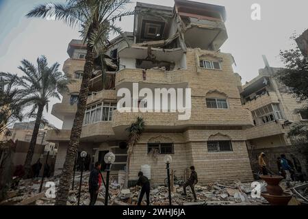 Rafah, Gaza. 9 febbraio 2024. I palestinesi controllano i detriti di un edificio distrutto in seguito al bombardamento israeliano su Rafah nella striscia di Gaza meridionale, sabato 10 febbraio 2024. 22 persone sono state uccise bombardamenti israeliani a Rafah compresi sfollati dal nord di Gaza, hanno detto i testimoni. Foto di Ismael Mohamad/UPI. Crediti: UPI/Alamy Live News Foto Stock