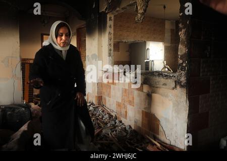 Rafah, Gaza. 9 febbraio 2024. Una donna palestinese controlla i detriti di una casa distrutta in seguito al bombardamento israeliano su Rafah, nella striscia di Gaza meridionale, sabato 10 febbraio 2024. 22 persone sono state uccise bombardamenti israeliani a Rafah compresi sfollati dal nord di Gaza, hanno detto i testimoni. Foto di Ismael Mohamad/UPI. Crediti: UPI/Alamy Live News Foto Stock